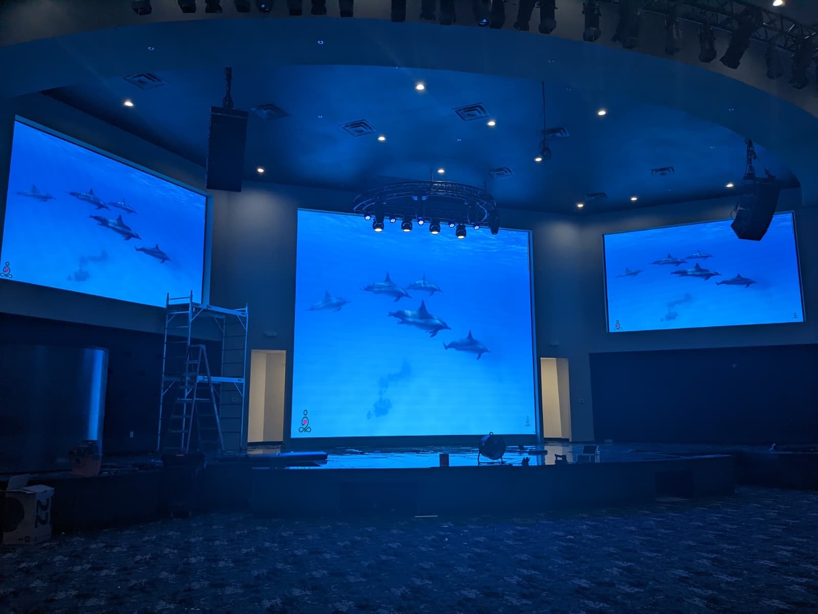 Auditorium with three large LED screens during final calibration