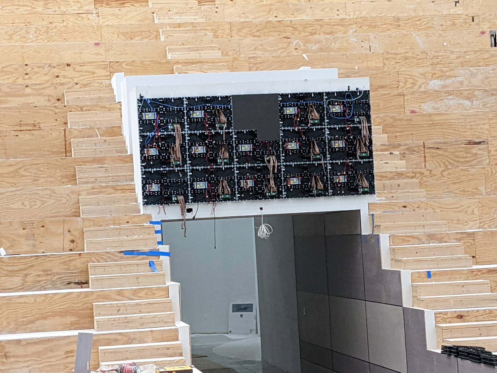 LED panel mounting structure installed above a doorway in an auditorium under construction