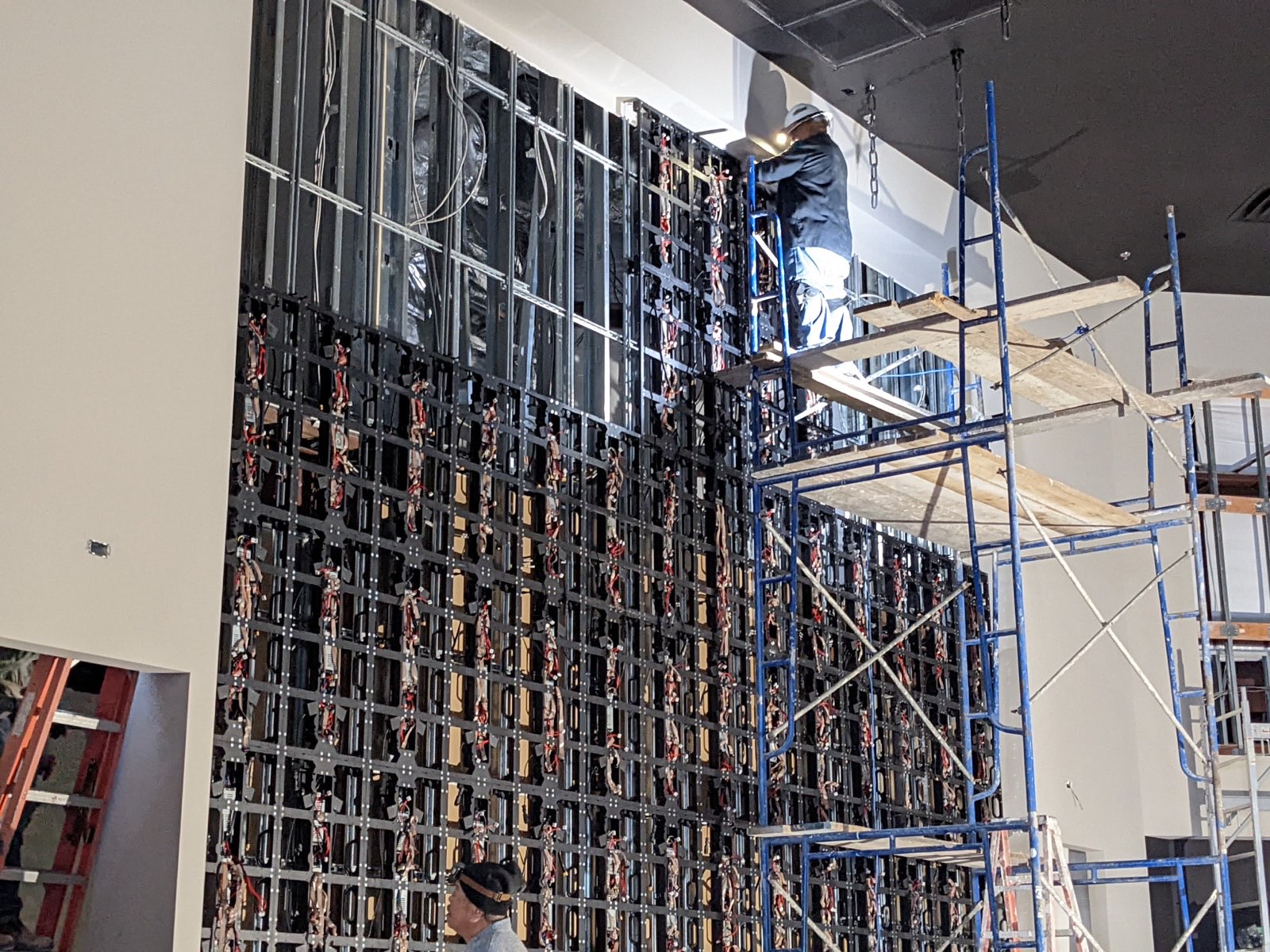 MSS Aesthetix technician mounting LED panel frames and receiving cards on scaffolding