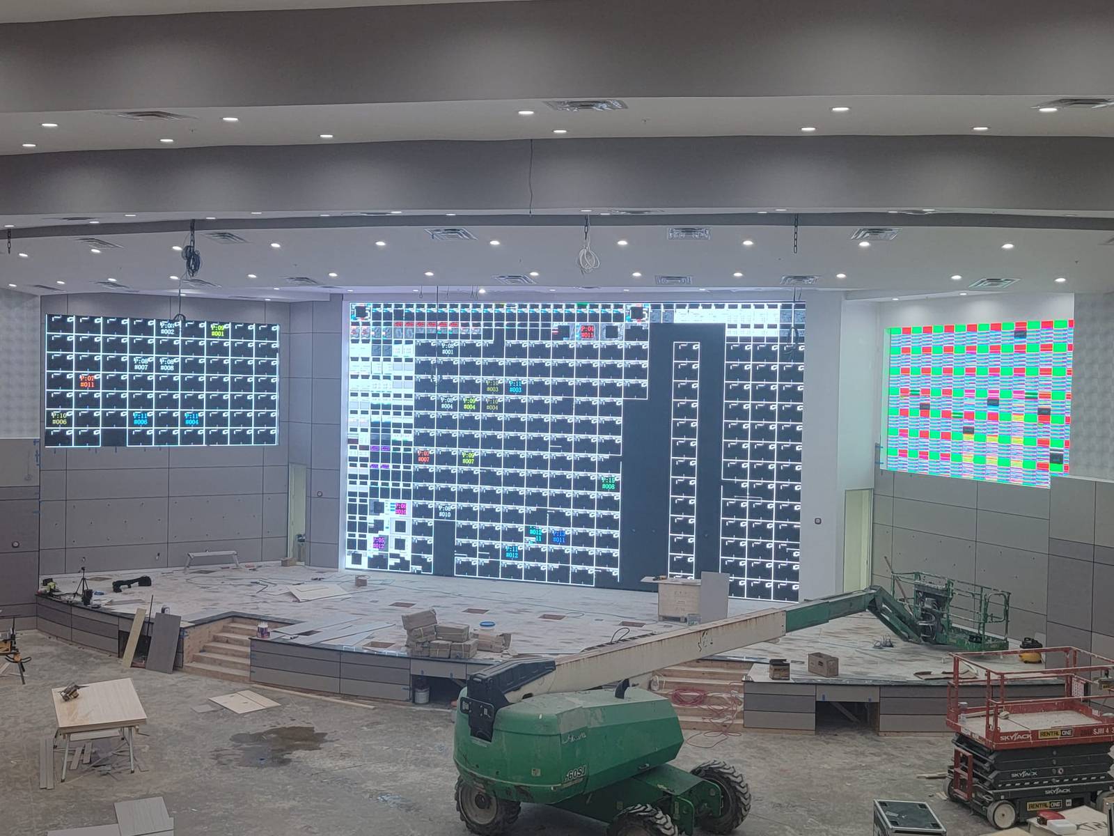 Technician on a boom lift working on an LED wall showing cabinet mapping IDs