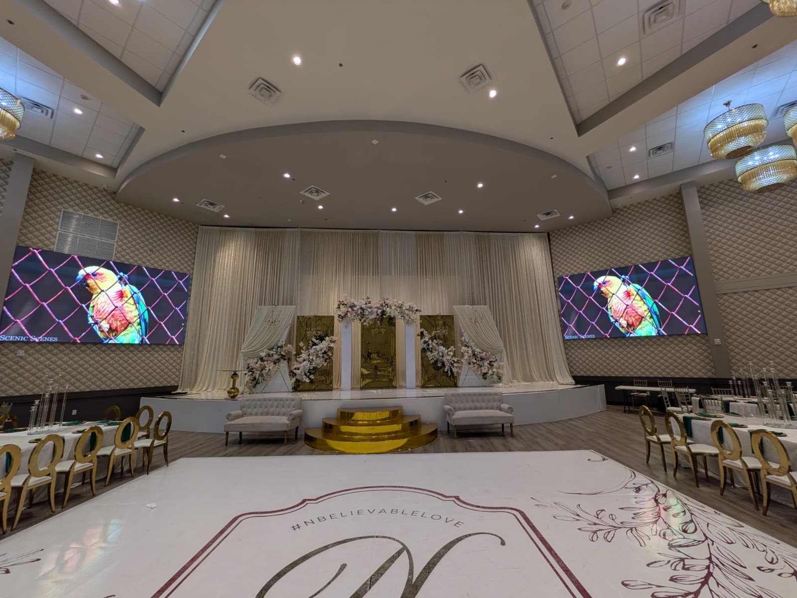 Event hall wedding setup with two flanking LED video walls